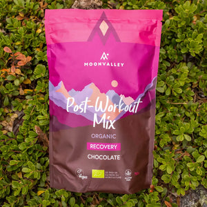 Moonvalley Bio-Regenerationsdrink mit Schokolade als Pulver, fotografiert in einer natürlichen Outdoor-Umgebung.