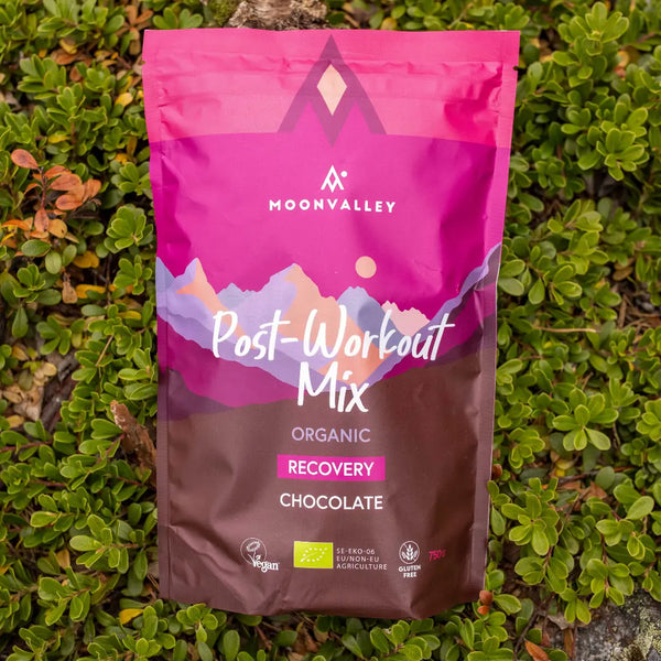 Moonvalley Bio-Regenerationsdrink mit Schokolade als Pulver, fotografiert in einer natürlichen Outdoor-Umgebung.