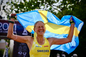 Moonvalley-Mitgründerin Ida Nilsson feiret en Sieg mit dr schwedische Flagge nach eme Trailrunning-Wettkampf.